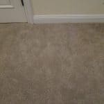 Stained beige carpet near doorjamb after patching carpet