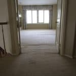 Beige loose and buckled carpet in double doorway and master bedroom before stretching carpet