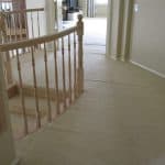 Beige loose and buckled carpet on landing above curved stairway before stretching carpet