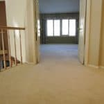 Beige loose and buckled carpet in double doorway and master bedroom after stretching carpet