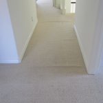 Loose and buckled off white berber carpet in hall before re-stretch